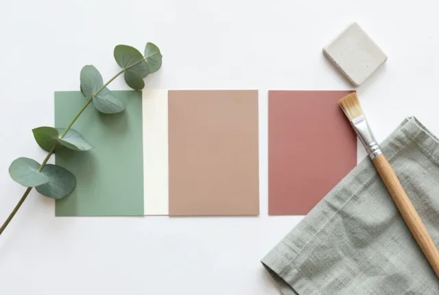 Brand color palette board with five paint swatches in sage cream taupe pink and terracotta with eucalyptus on white
