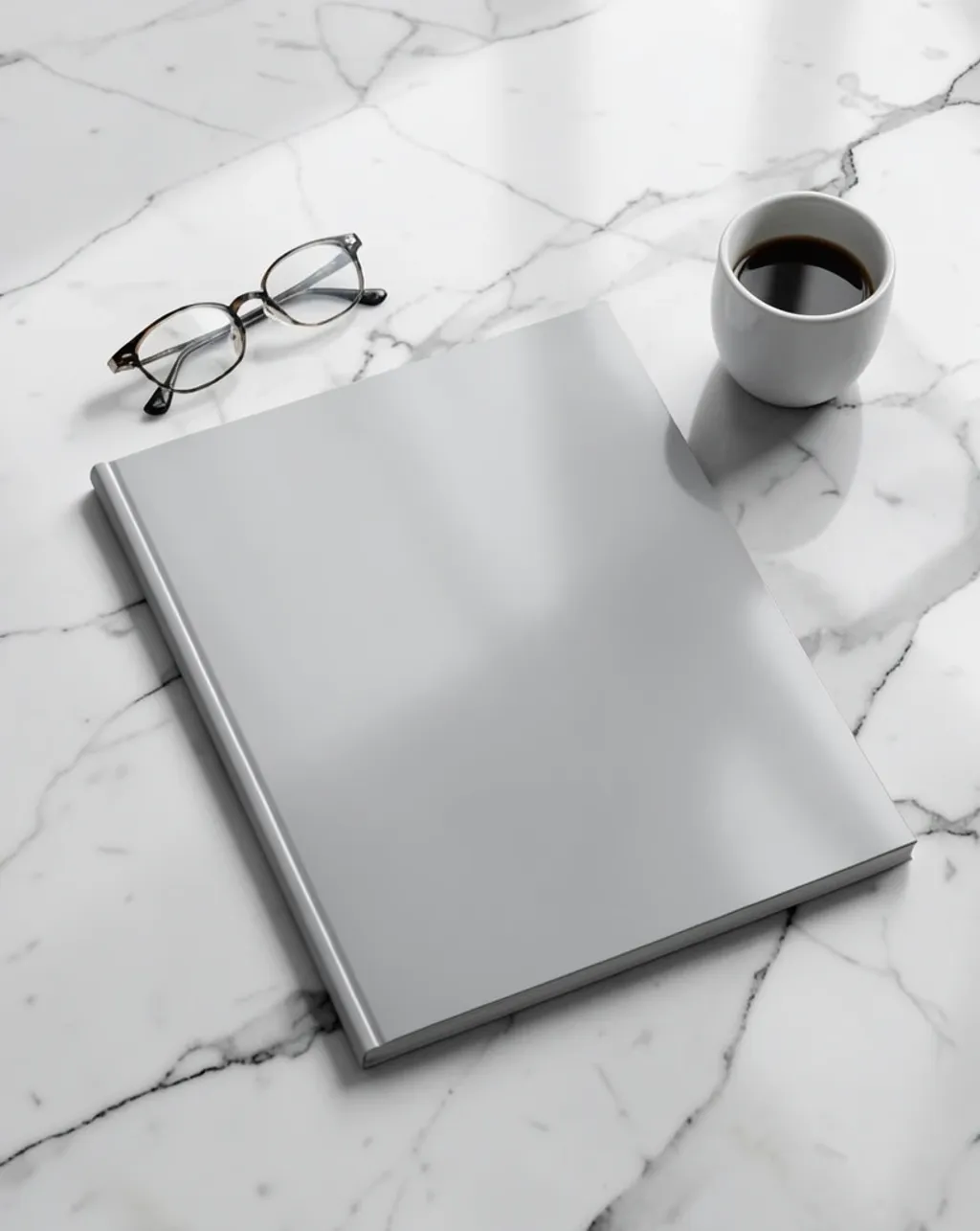 Glossy magazine with blank cover and spine on marble beside glasses and coffee cup